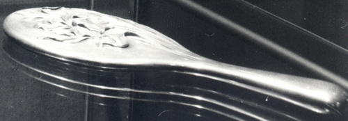 Зеркало ручное овальное в серебряной оправе, с рельефным изображением ирисов на обороте. 